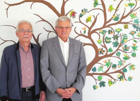 Günter Vollmer (links) und Günther Brenzel in der Geschäftsstelle des Hospizdienstes Gomaringen, wo ein gemalter Baum die Wand ziert. Die Schmetterlinge auf den Blättern tragen die Namen der Verstorbenen, die die Hospizdienst-Mitglieder betreut haben. Bild: Schweizer